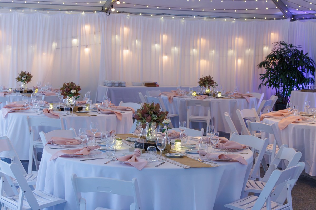 The silk-lined marquee interior styled with round tables, blush napkins and fairy lights.