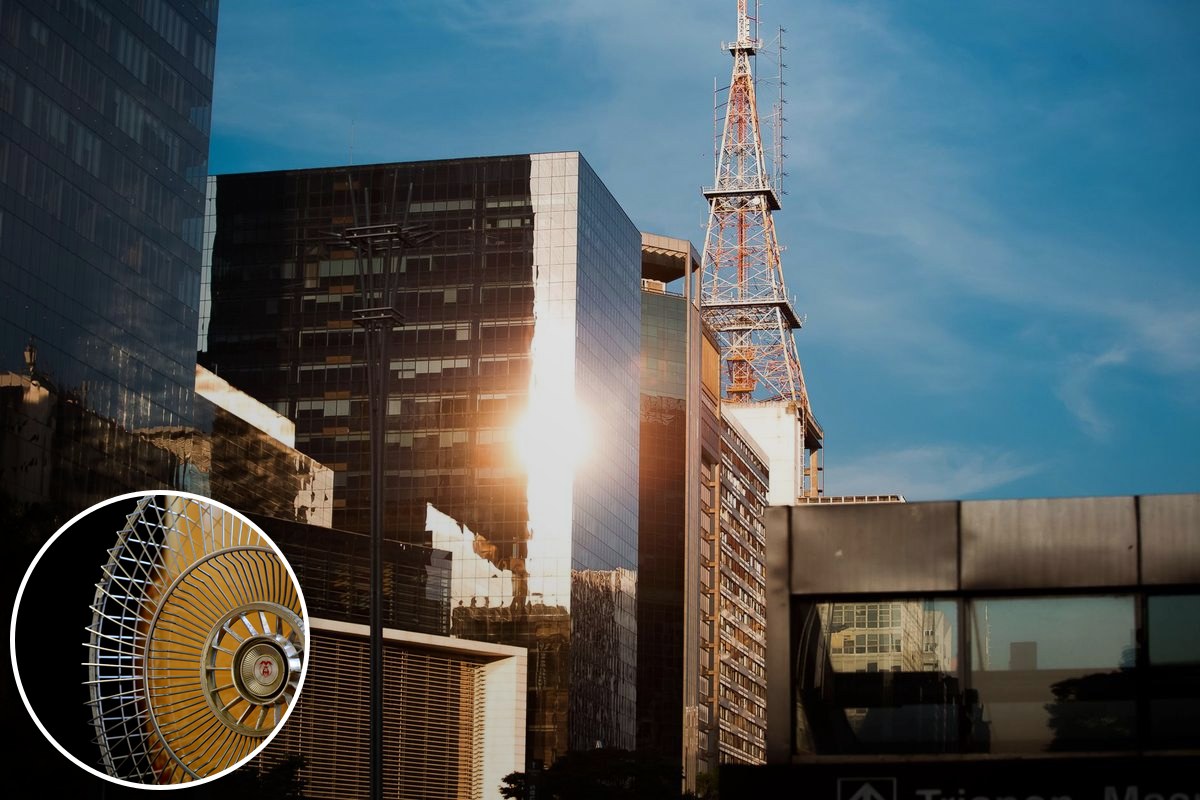 Sunlight glares off glass office towers under a clear sky.