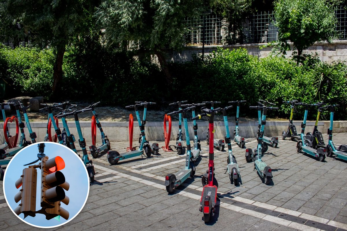 Rows of shared e-scooters parked on a paved city footpath.