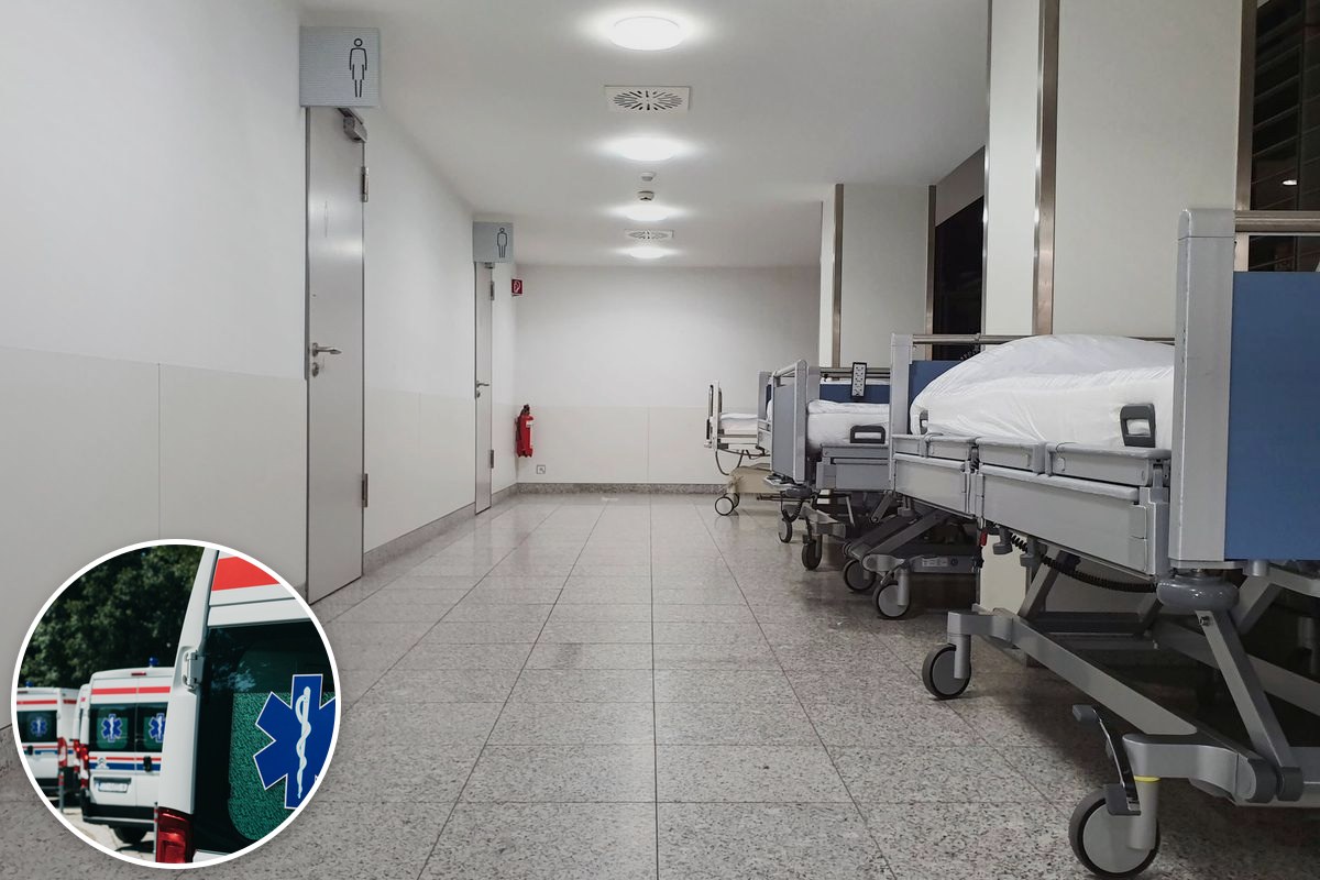 Empty hospital beds lined along a corridor.