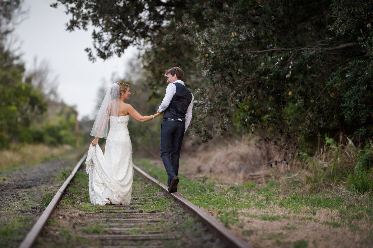 The Sent With Love founders on their wedding day, walking hand in hand along an old railway line through the bush.